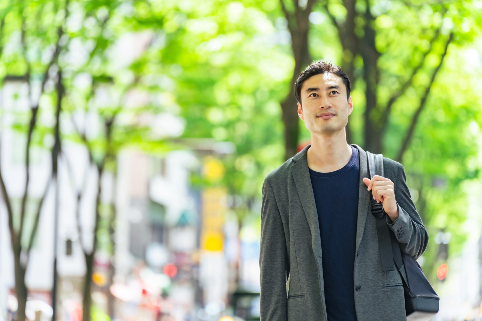 A man walking in the fresh green city area.