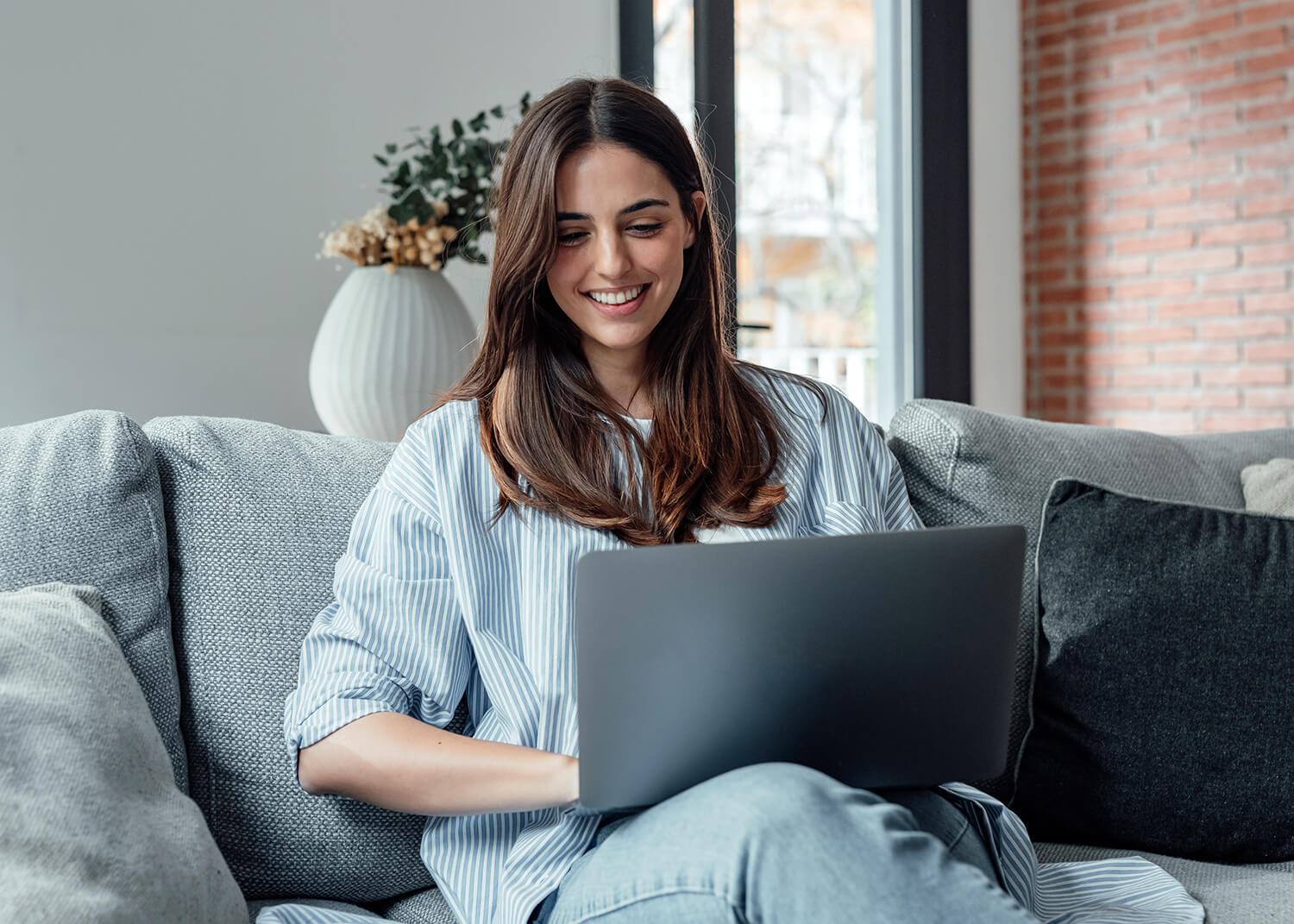 Young woman using a laptop on a couch